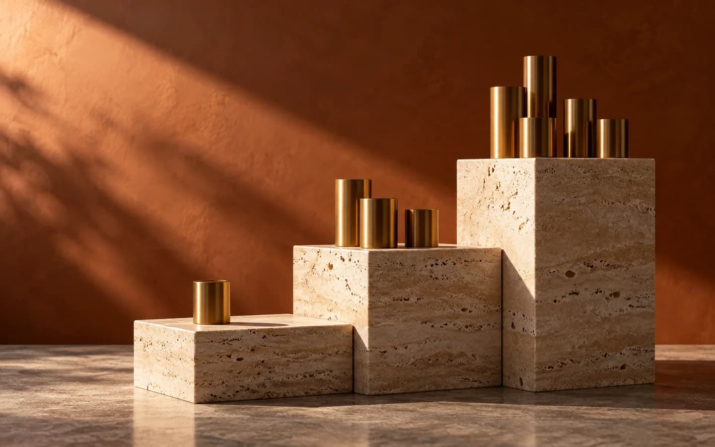 Three travertine plinths with increasing groups of brass cylinders.